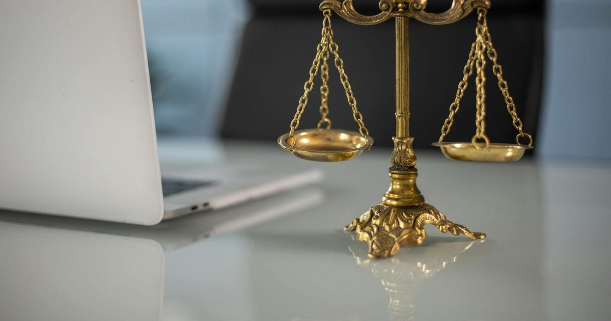 Balança da justiça sobre a mesa de um escritório de advocacia